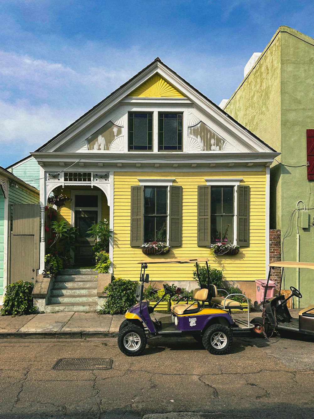 a golf cart parked in front of a yellow house