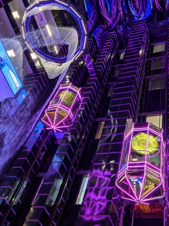 Isometric illustration of a futuristic workspace with glowing data charts and AI interfaces in neon blue and violet tones.