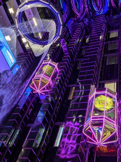 Futuristic 3D printed decorative items glowing with turquoise neon light on a dark background