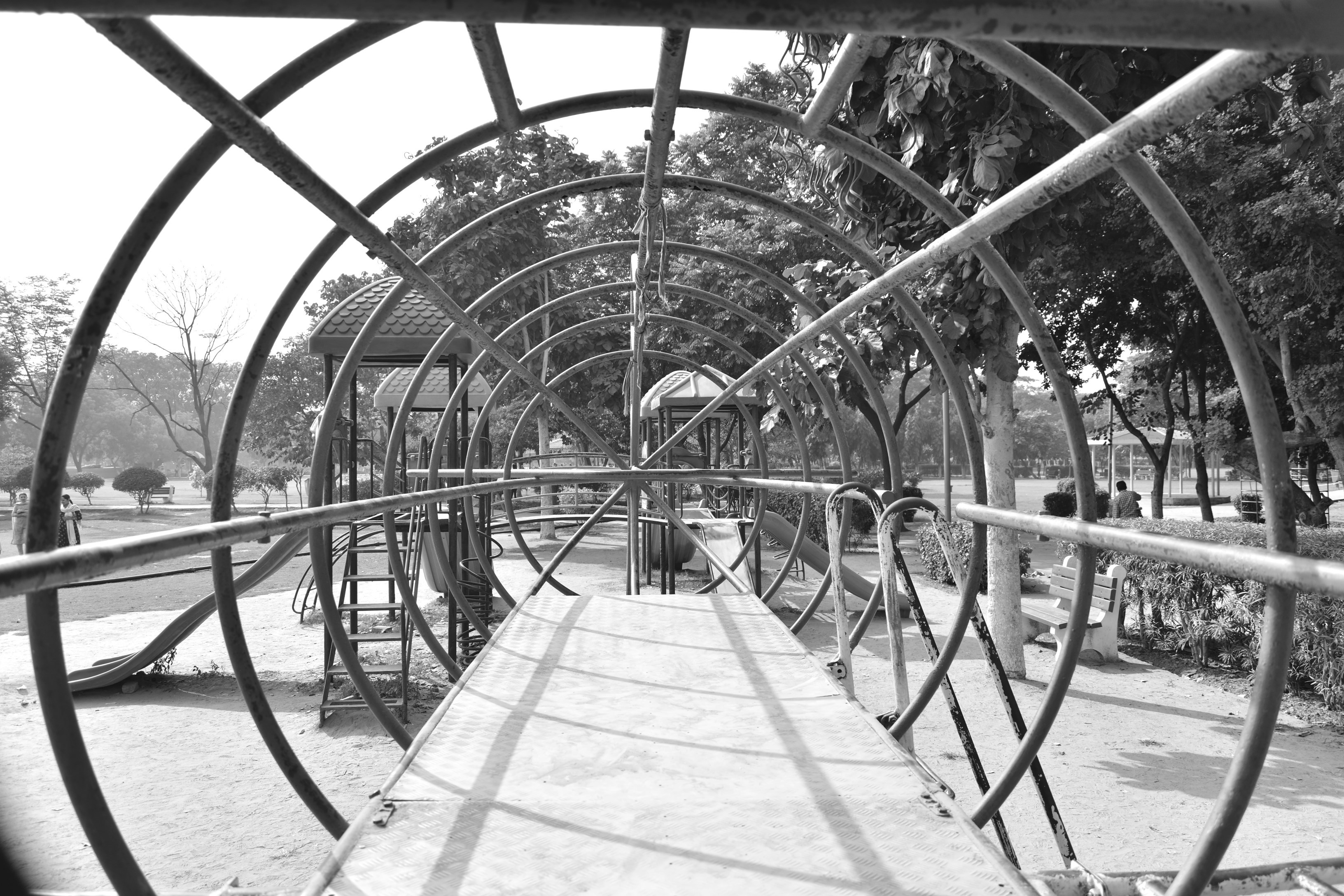 A black and white photo of a walkway in a park