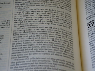 Close-up of an open book with highlighted passages on religious studies.