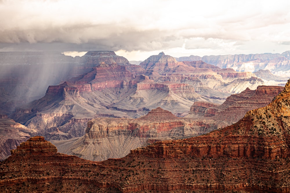 the sun shines through the clouds over the grand canyon