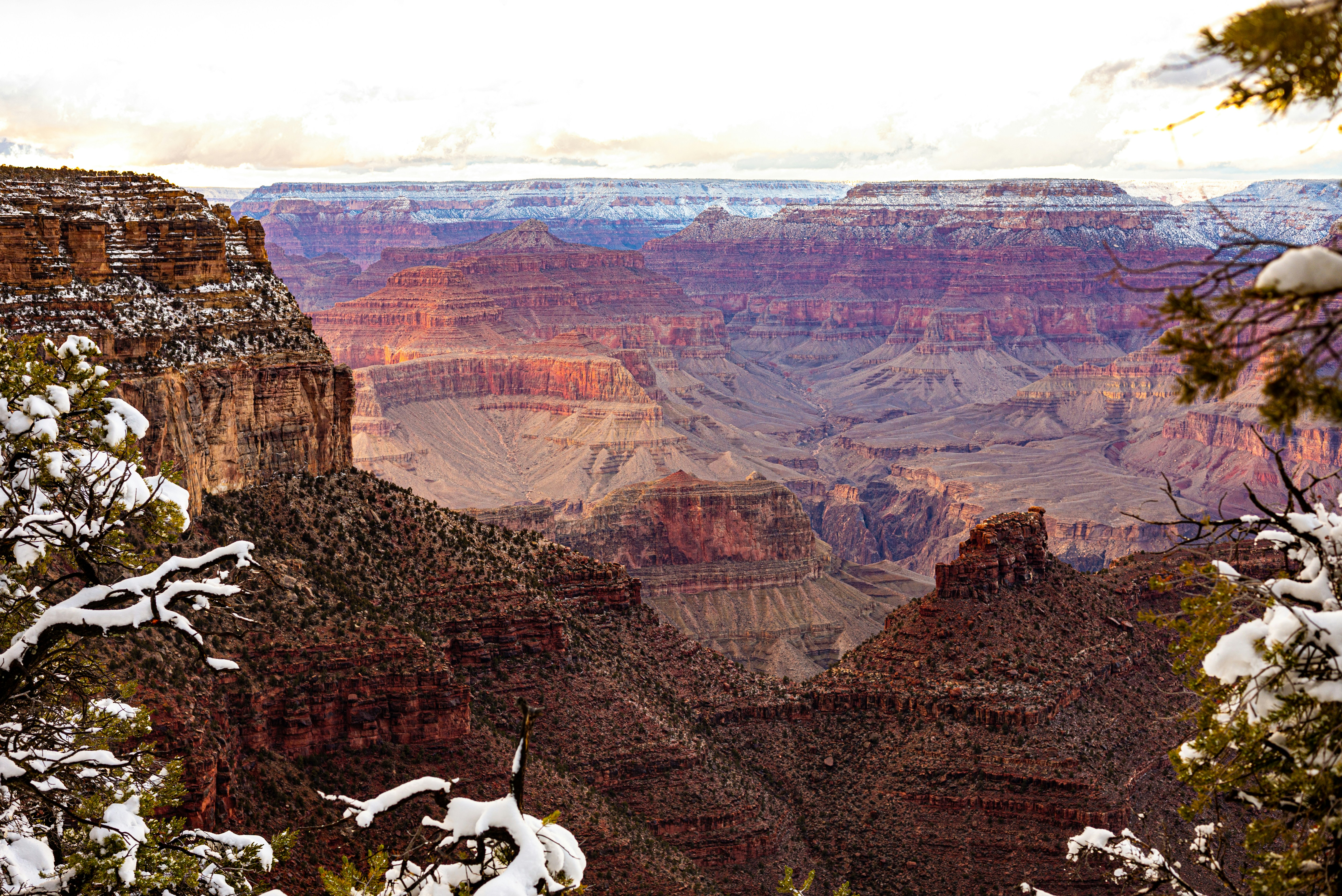 a view of the grand canyon in winter, red mountains