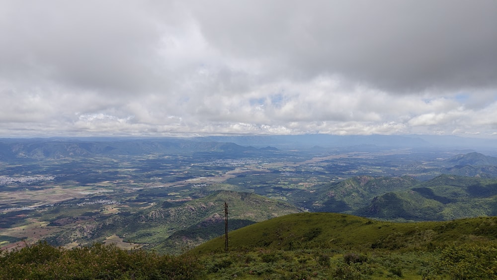 a view of a valley and mountains from the top of a hill