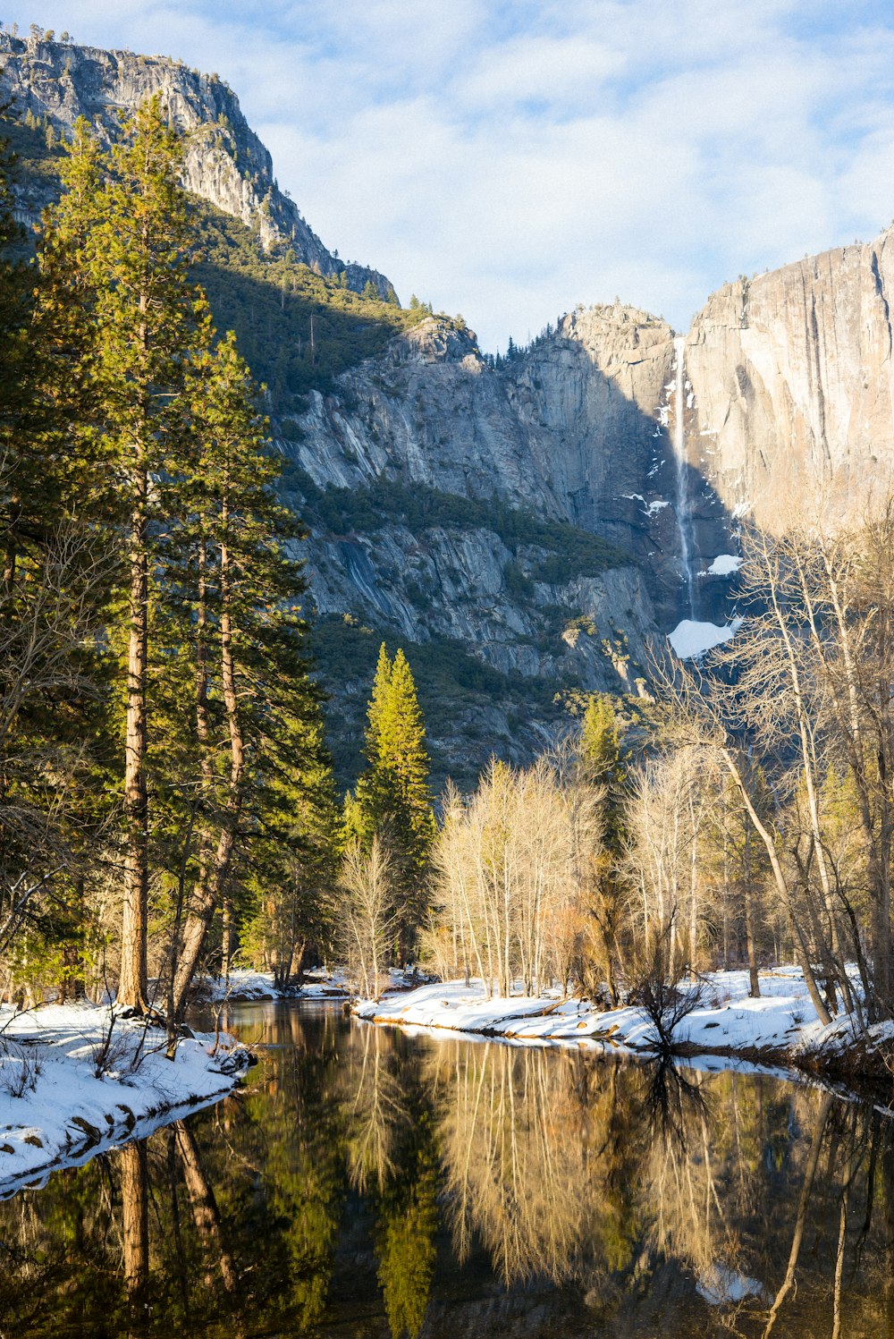 a river surrounded by snow covered mountains and trees