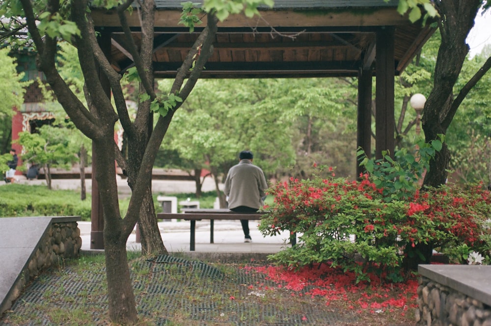 a man sitting on a bench in a park