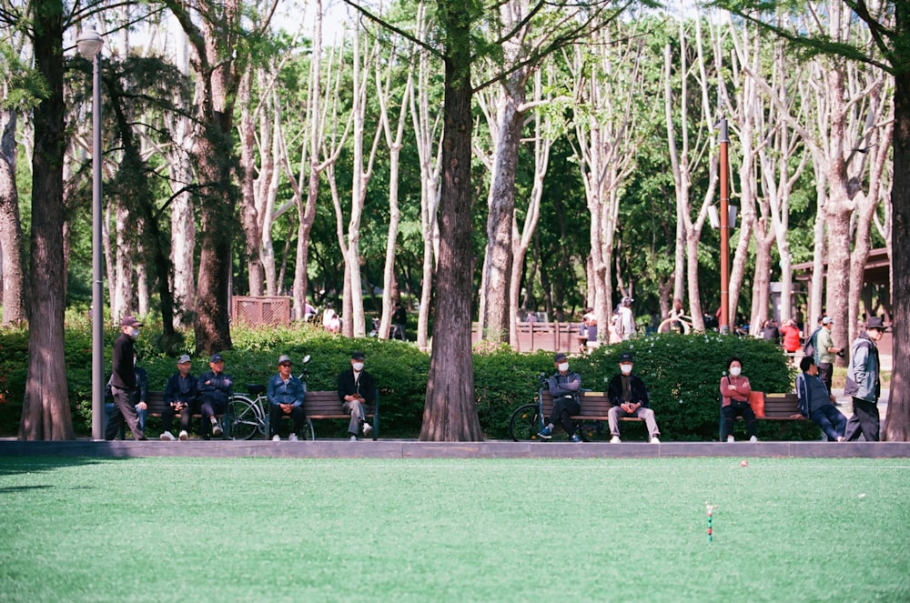 a group of people sitting on a park bench