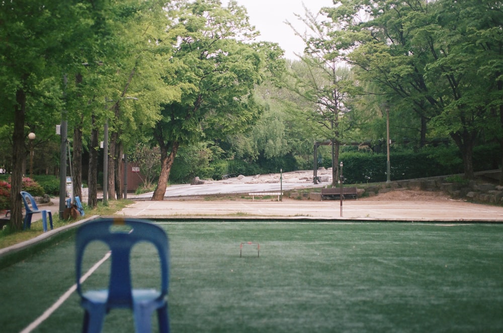 a tennis court surrounded by trees and people