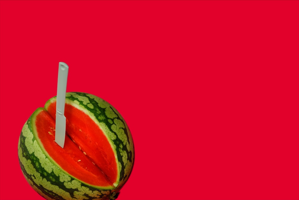 a watermelon with a toothbrush sticking out of it