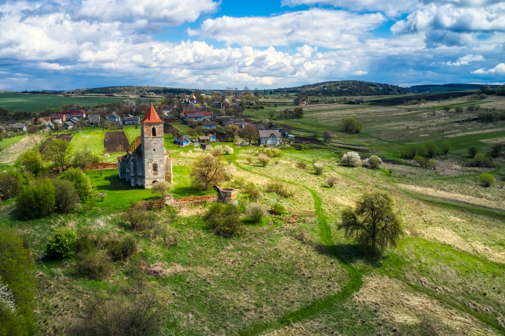 an aerial view of a small church in the middle of a field
