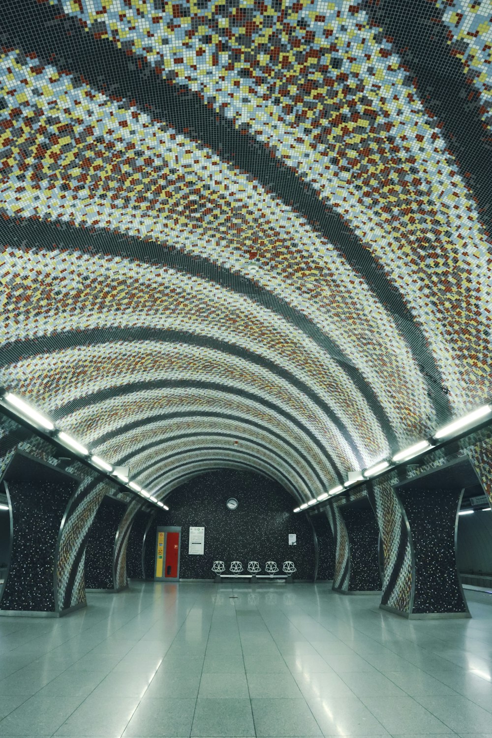 a subway station with a tiled ceiling and tiled floors