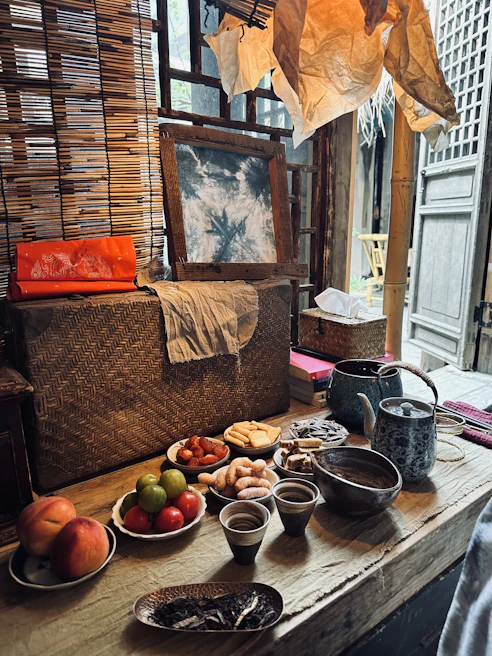 A rustic wooden table set with a traditional feast featuring local delicacies and handcrafted pottery.