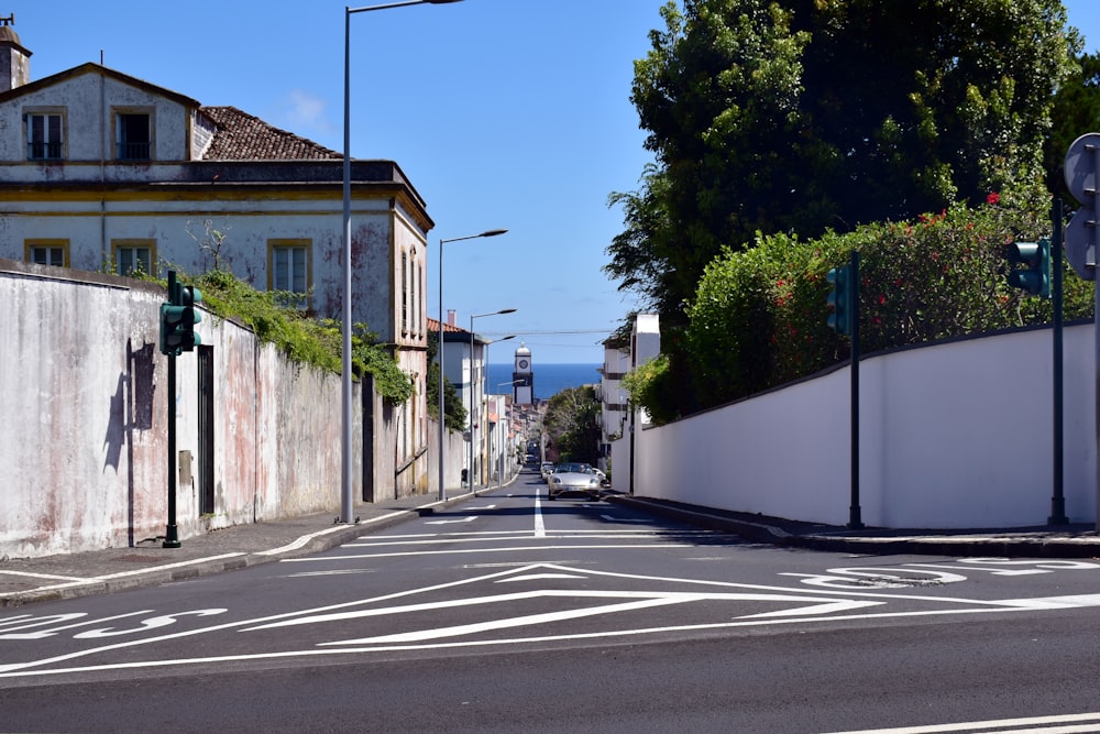 a street with a white wall and a street light