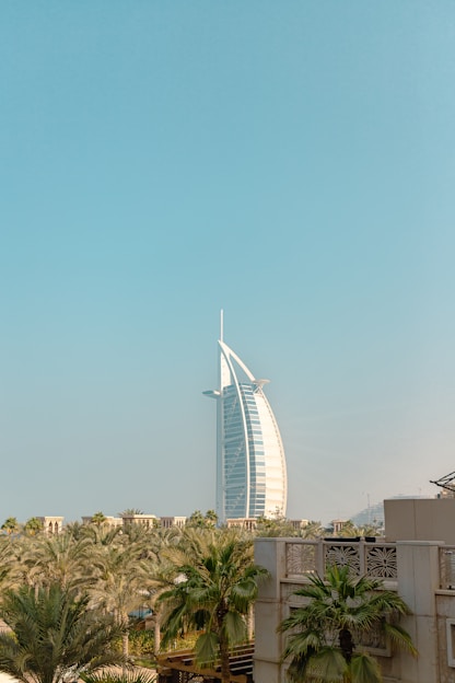 a tall building towering over a city next to palm trees