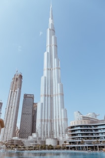 a tall building towering over a city next to a body of water
