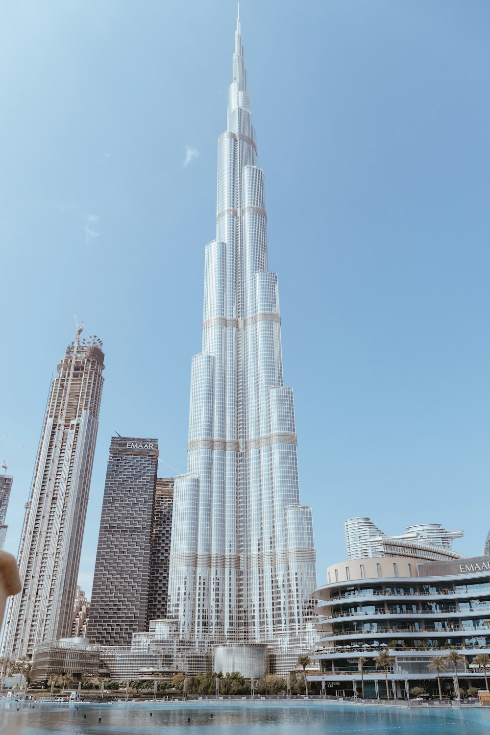 a tall building towering over a city next to a body of water