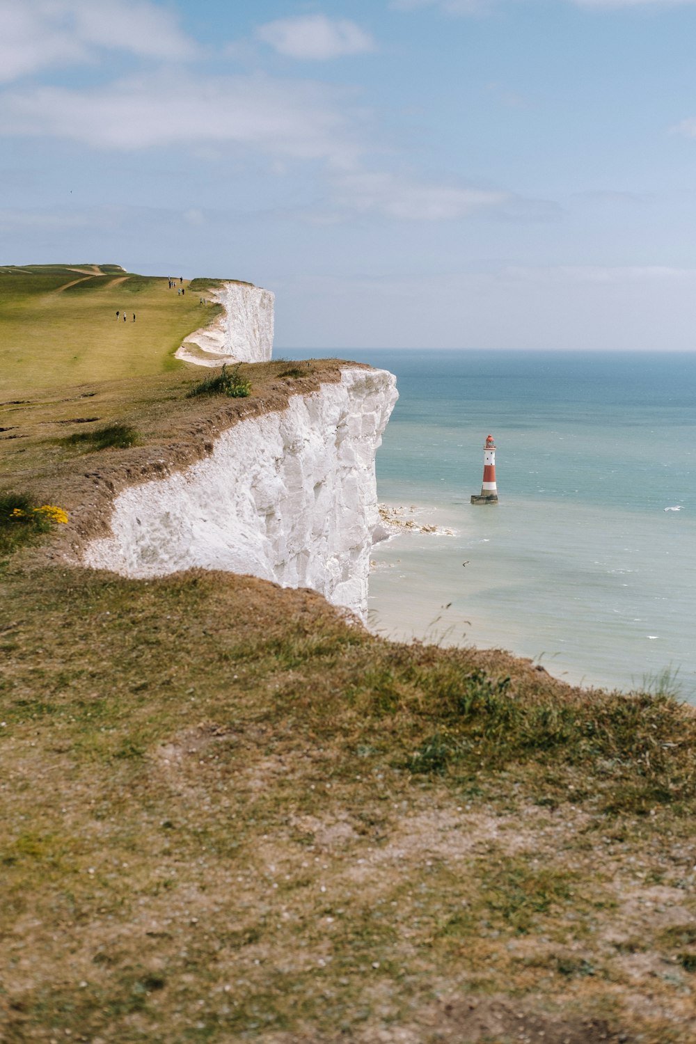 a person standing on the edge of a cliff near the ocean