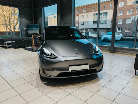 A sleek electric car prototype under bright showroom lights.