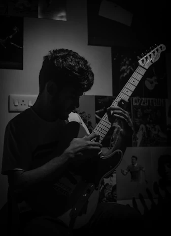 A candid photo of Silvan playing guitar passionately in a cozy room.