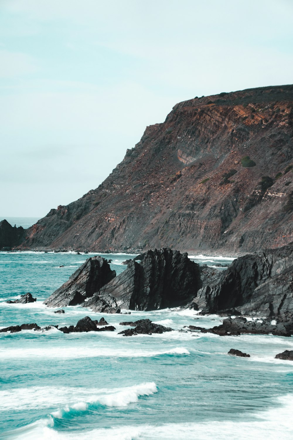 a large body of water next to a rocky shore