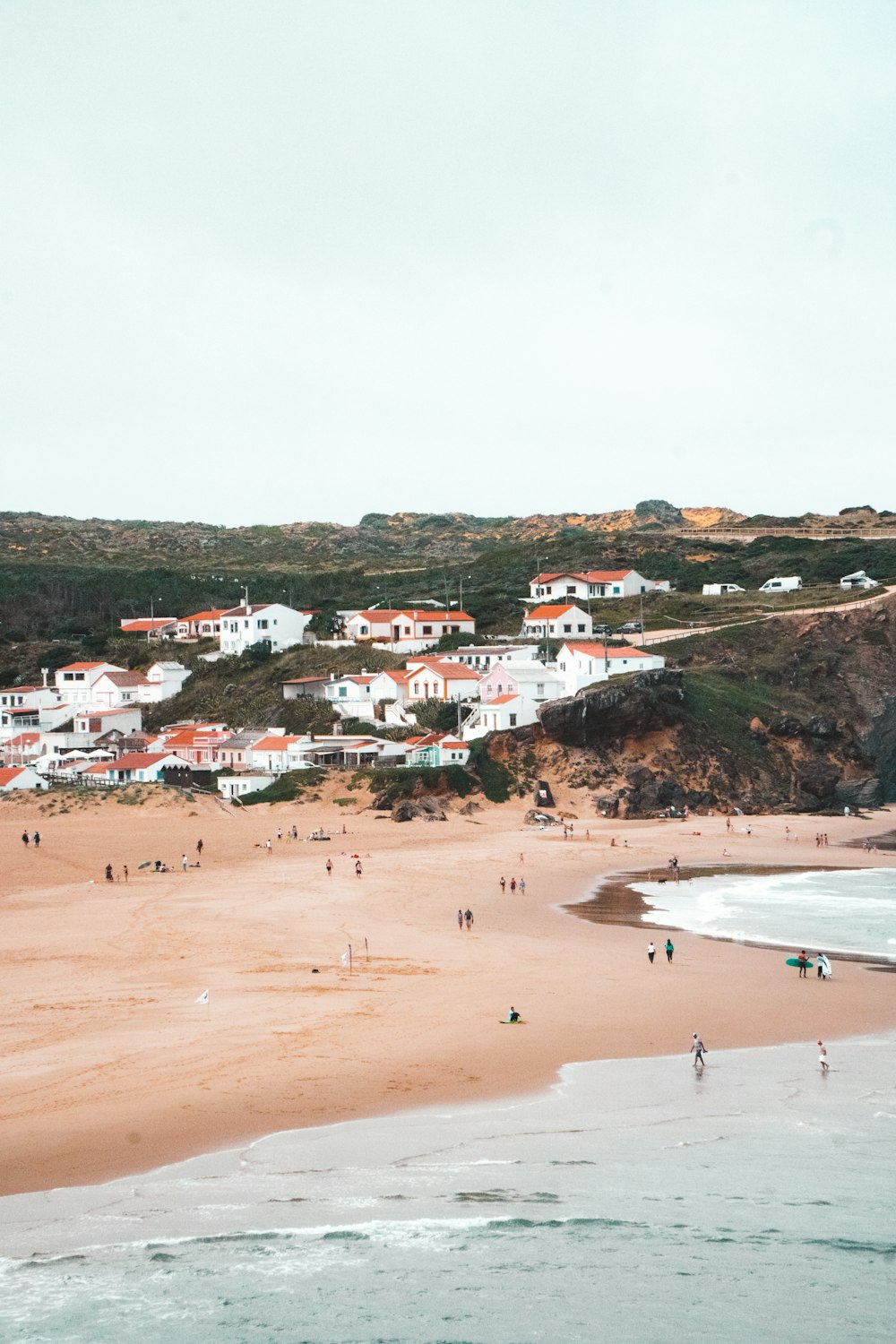 a group of people standing on top of a sandy beach