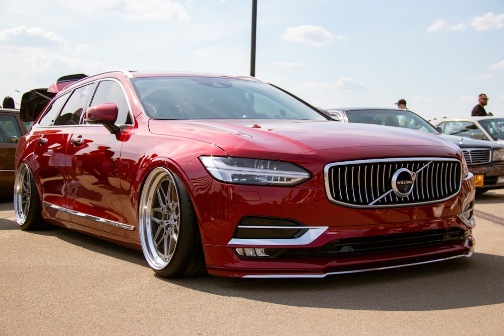 a red volvo car parked in a parking lot