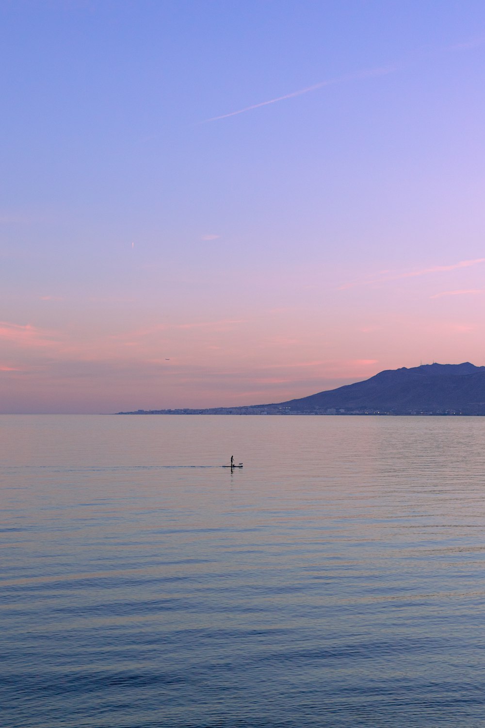 a lone boat floating in the middle of a large body of water