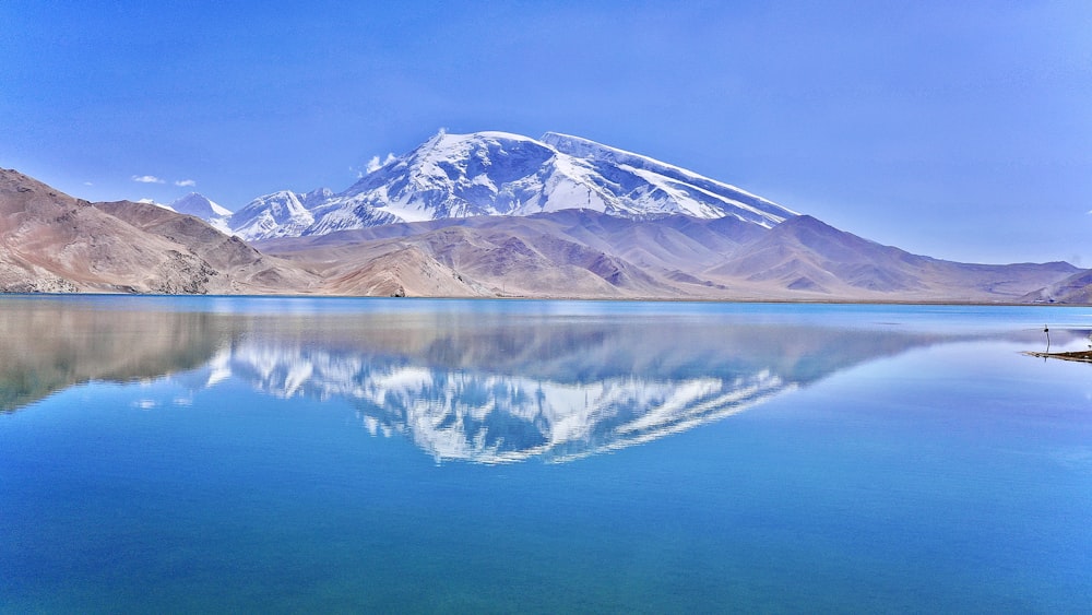 a large body of water with a mountain in the background