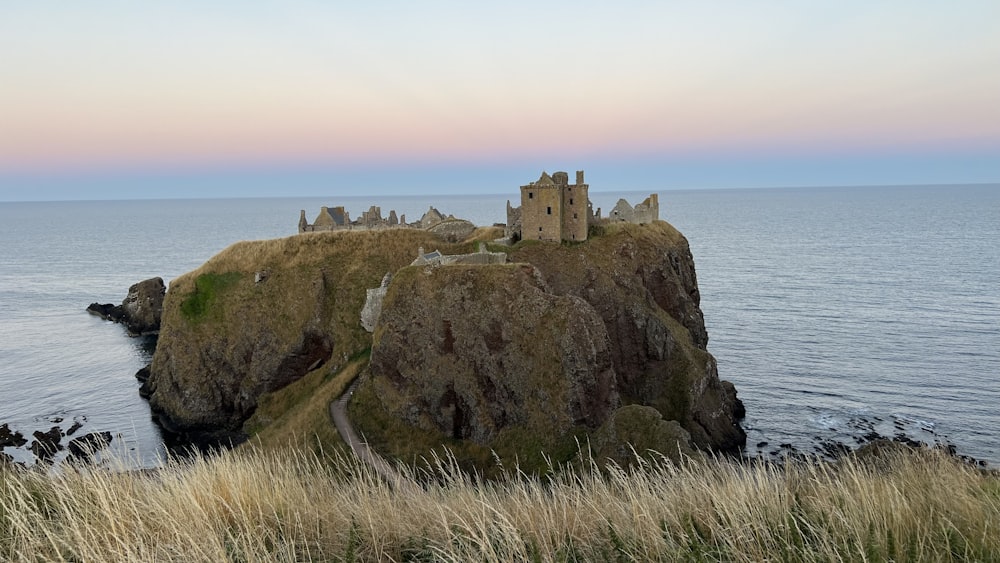 a castle sitting on top of a cliff next to the ocean