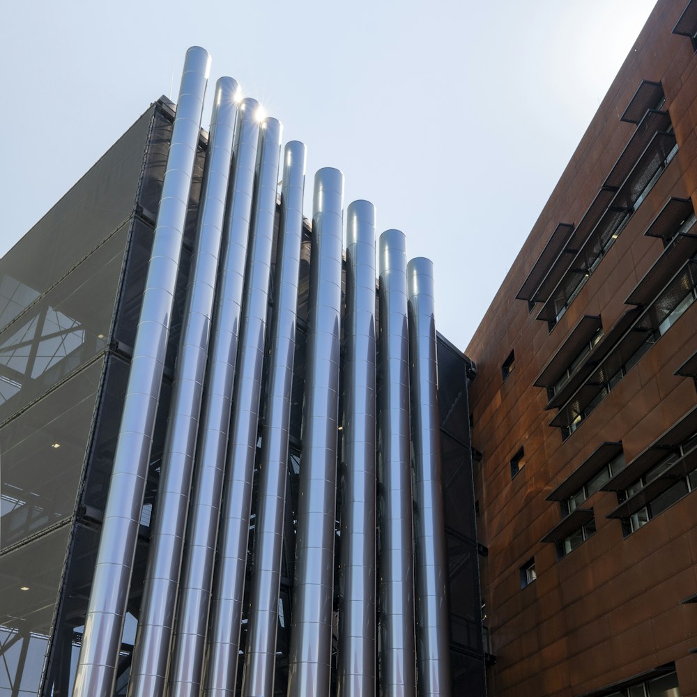 a tall building with a bunch of metal pipes on it's side