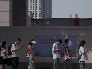 A friendly gig worker checking a digital map on their phone while waiting in line.