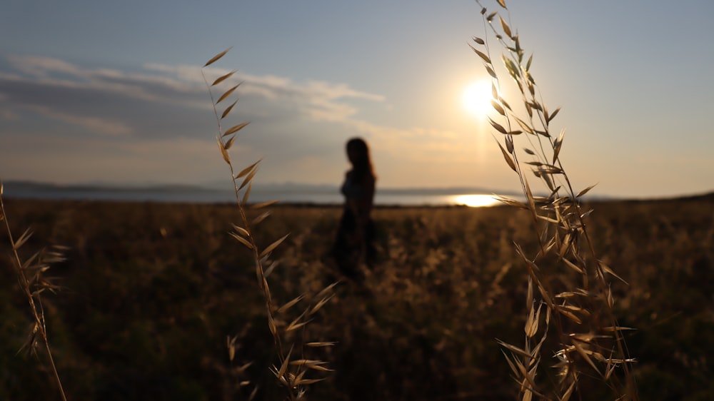 a woman standing in a field of tall grass