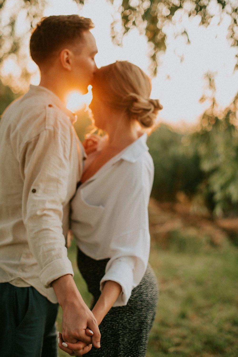 a man and a woman holding hands in a field