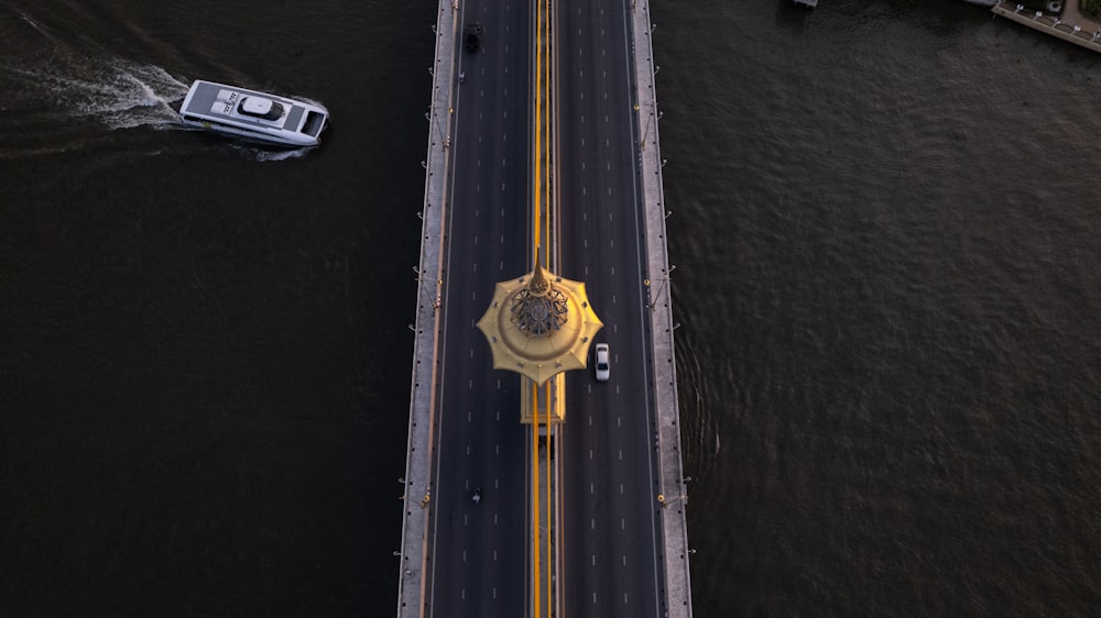 an aerial view of a bridge and a boat on the water