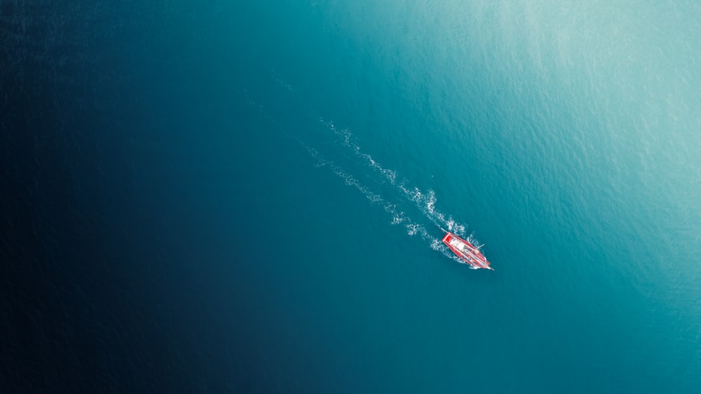 a red boat in the middle of the ocean