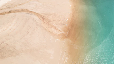 Aerial view of a serene beach with clear waters.