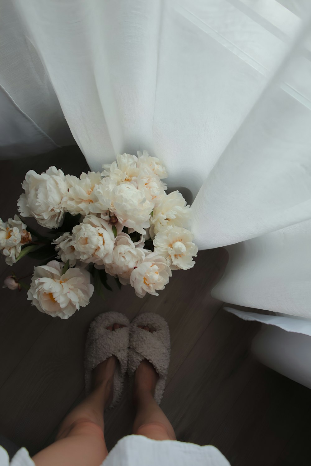 a person standing under a white sheet with flowers