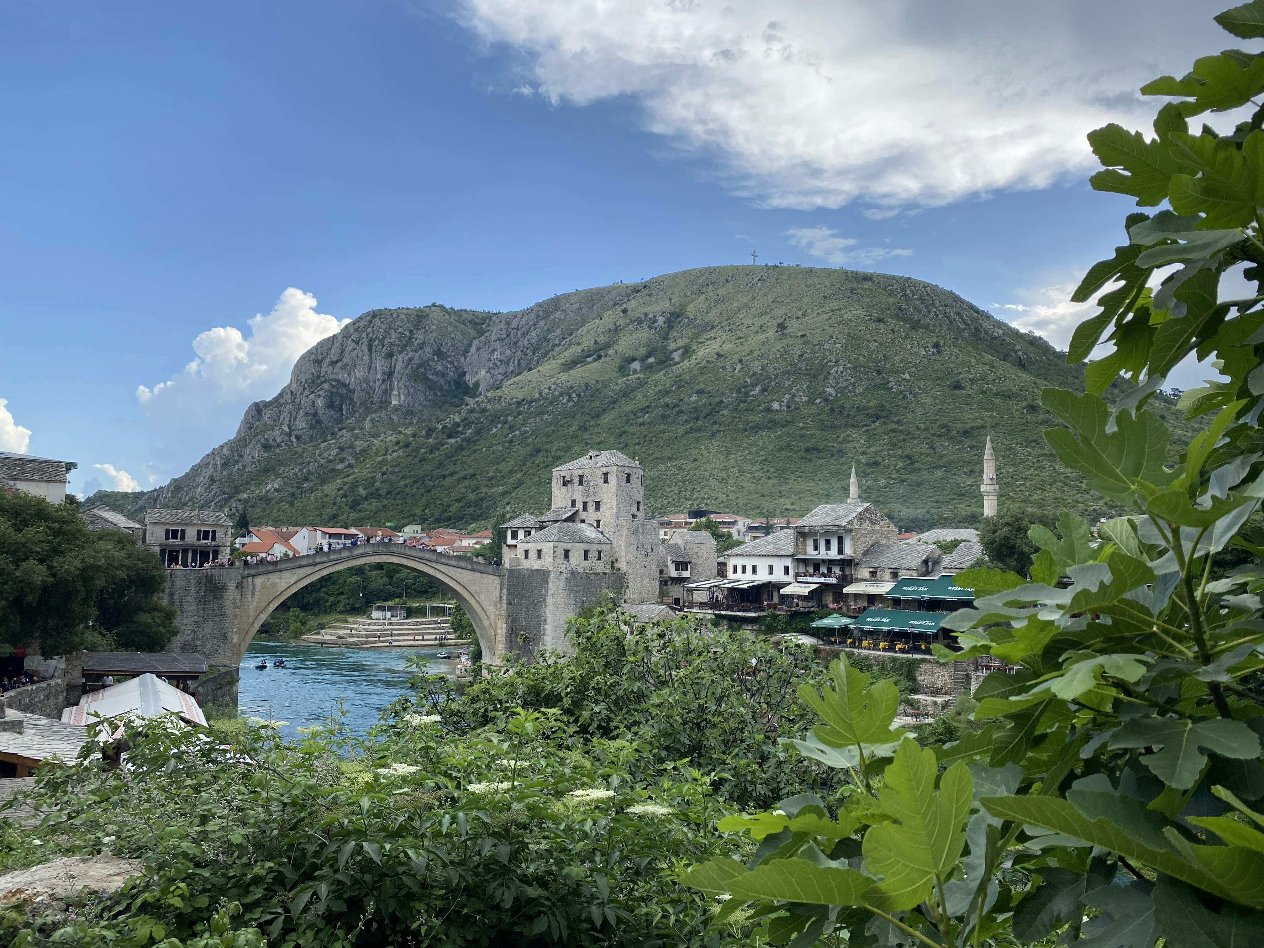 a bridge over a river with a mountain in the background