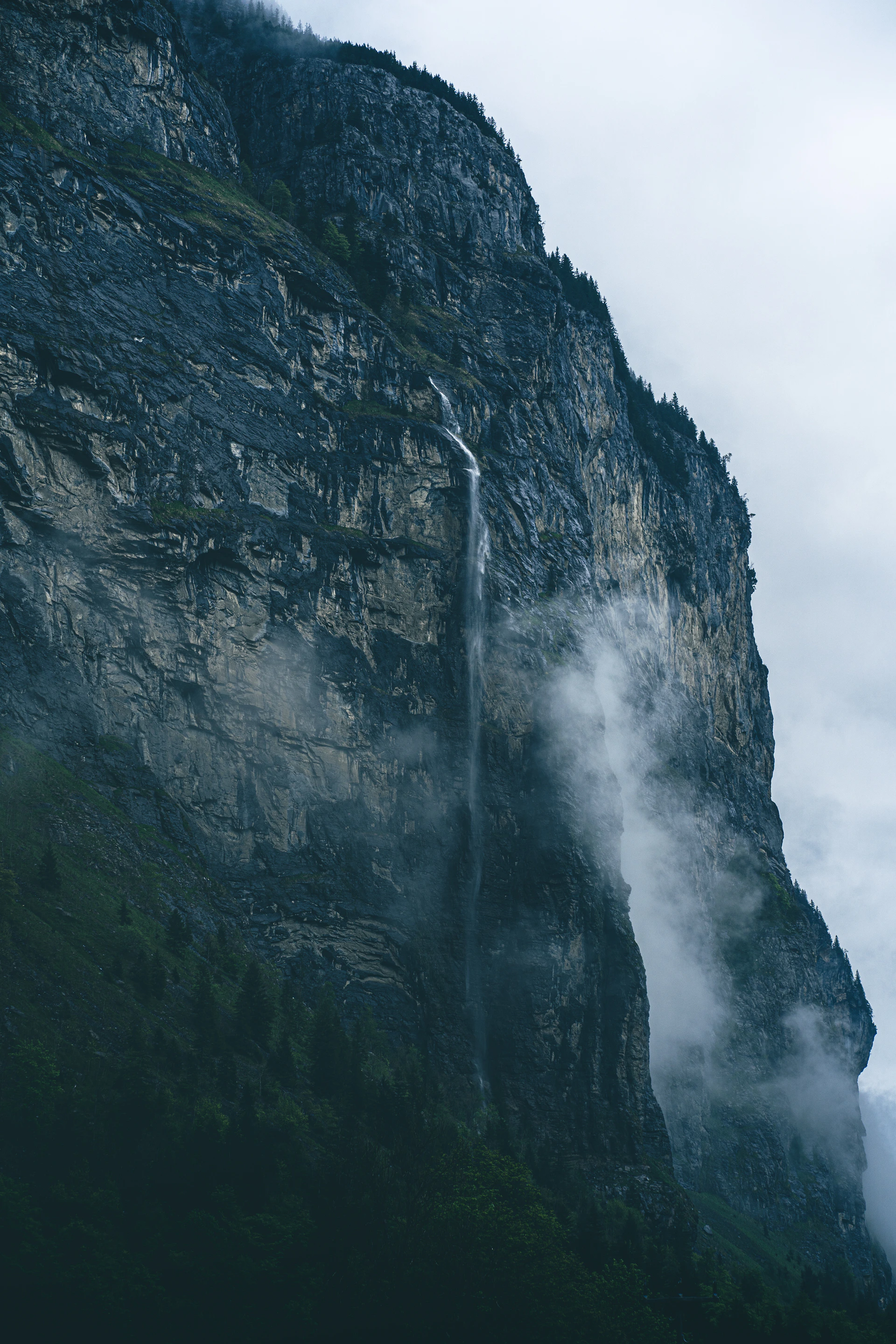 a tall mountain with a waterfall coming out of it