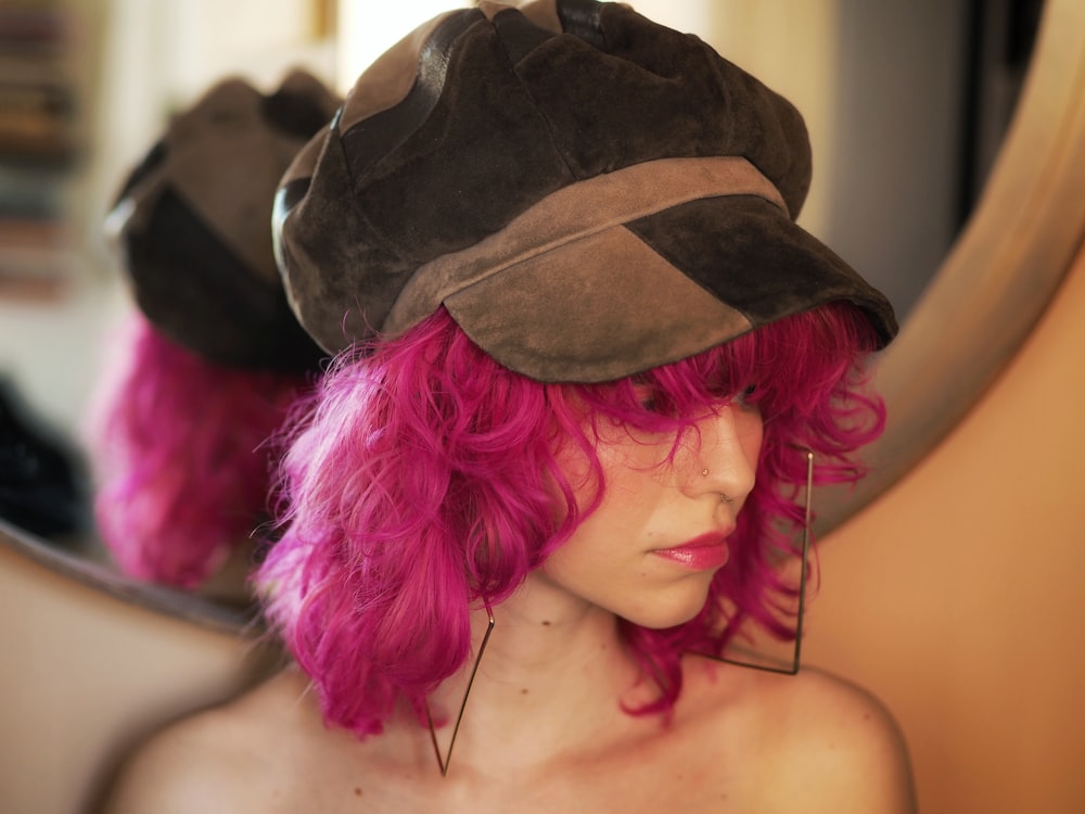 a mannequin with pink hair wearing a hat