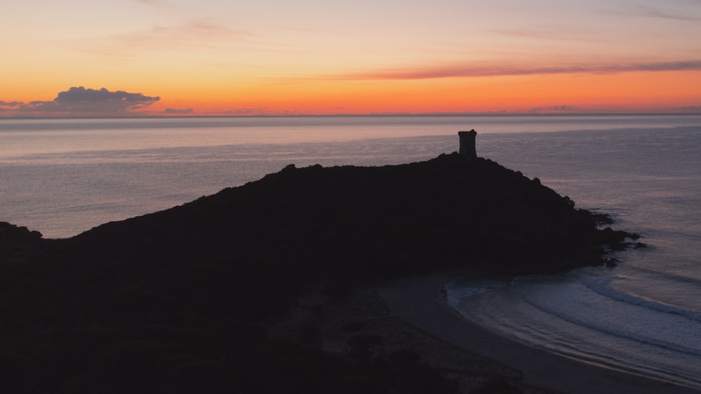 a lighthouse on a small island in the middle of the ocean