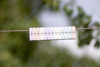 Soft pastel baby onesies hanging on a clothesline outdoors