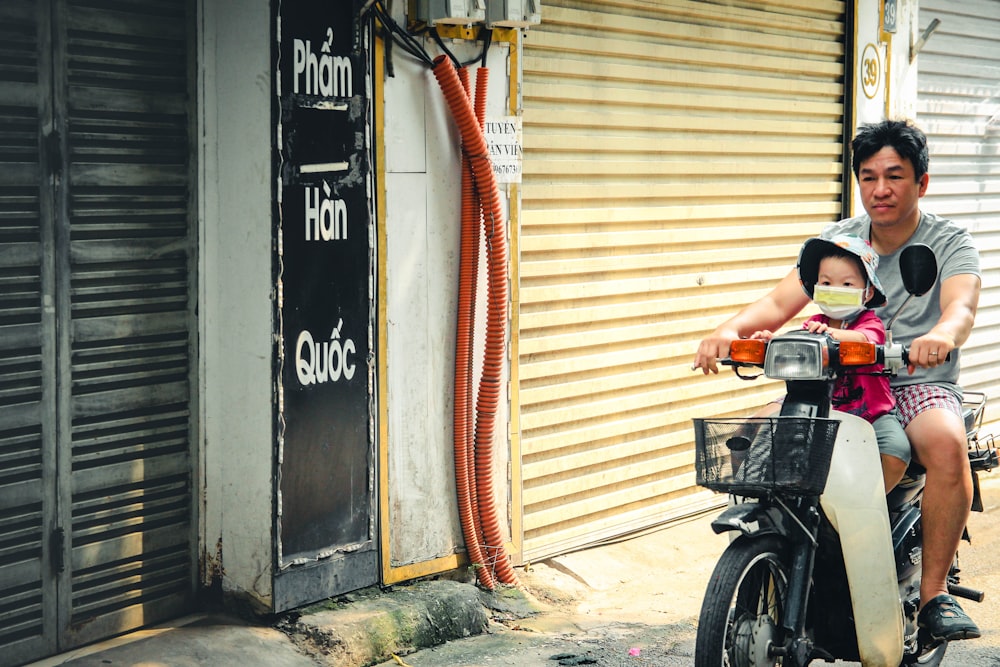 a man and a little girl riding a scooter