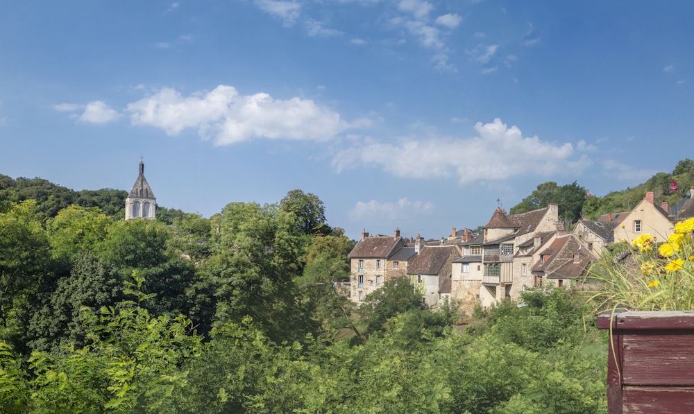 a view of a village with a church steeple in the background