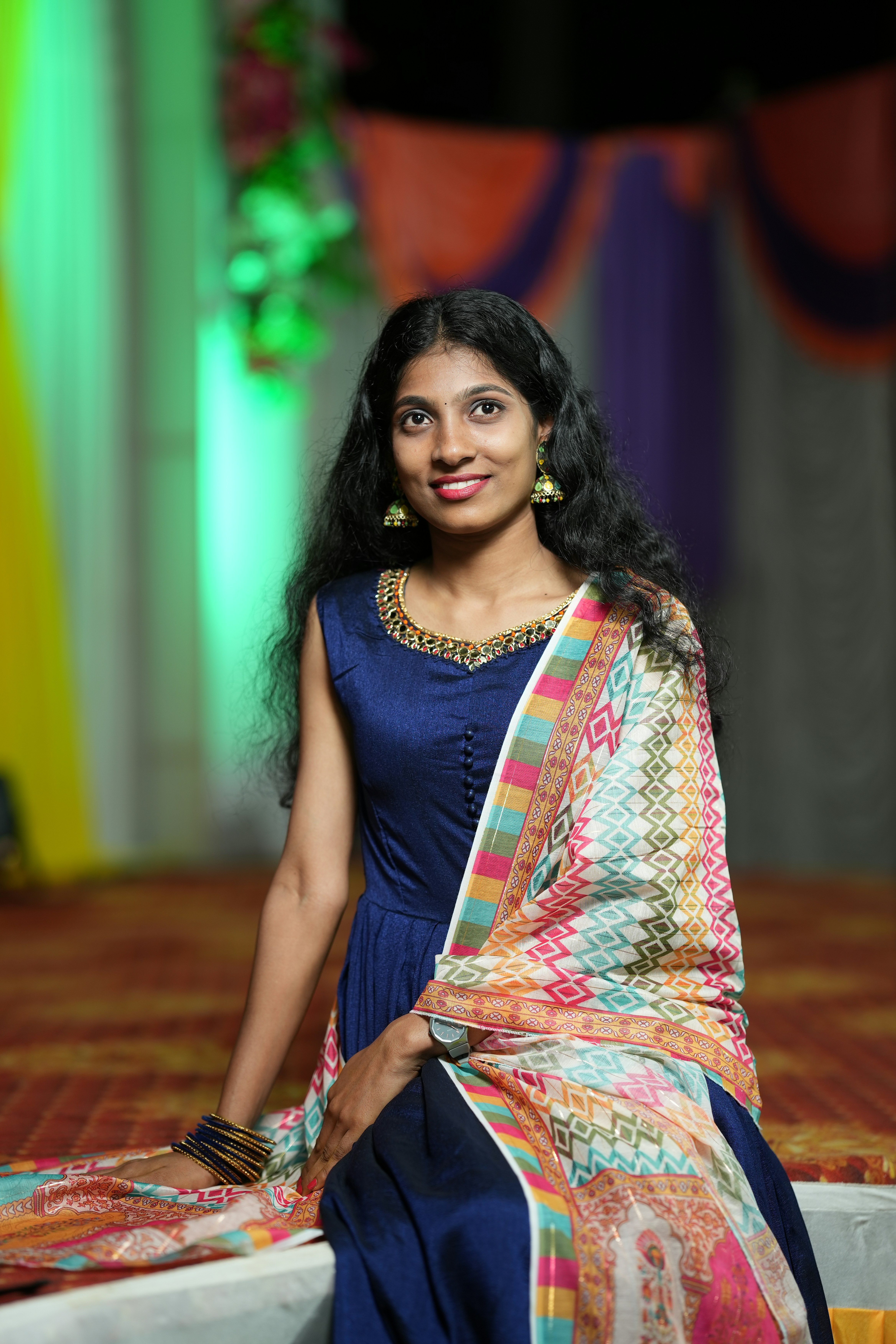 Indian woman in traditional dupatta smiling warmly against a bright background