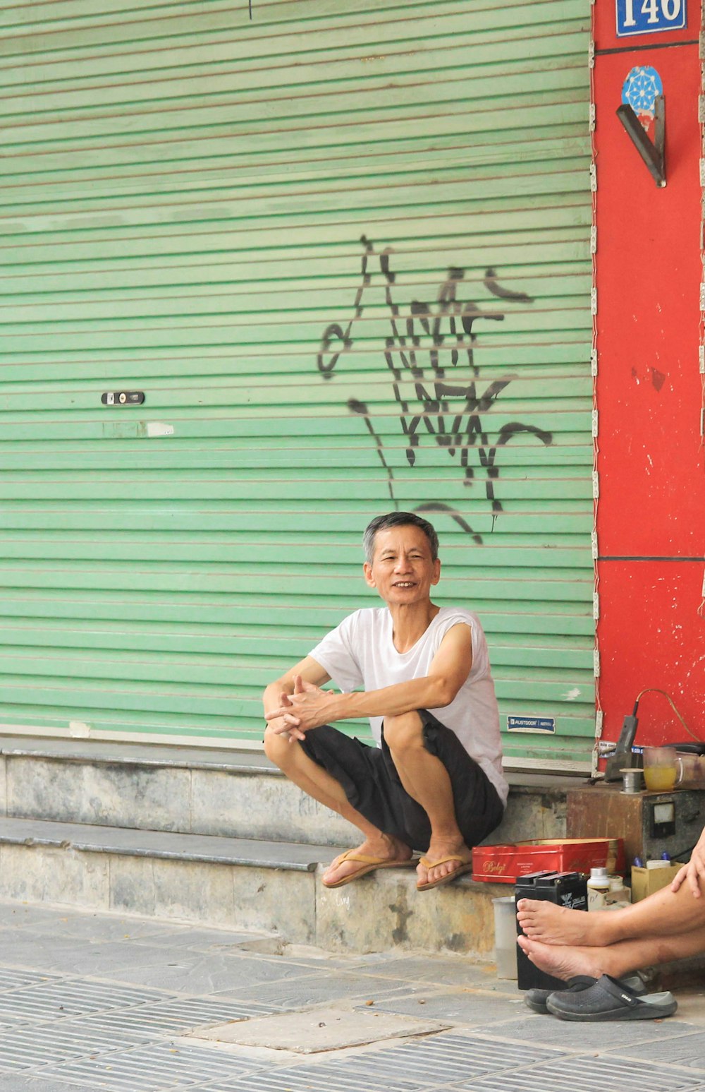 a man sitting on a step next to another man