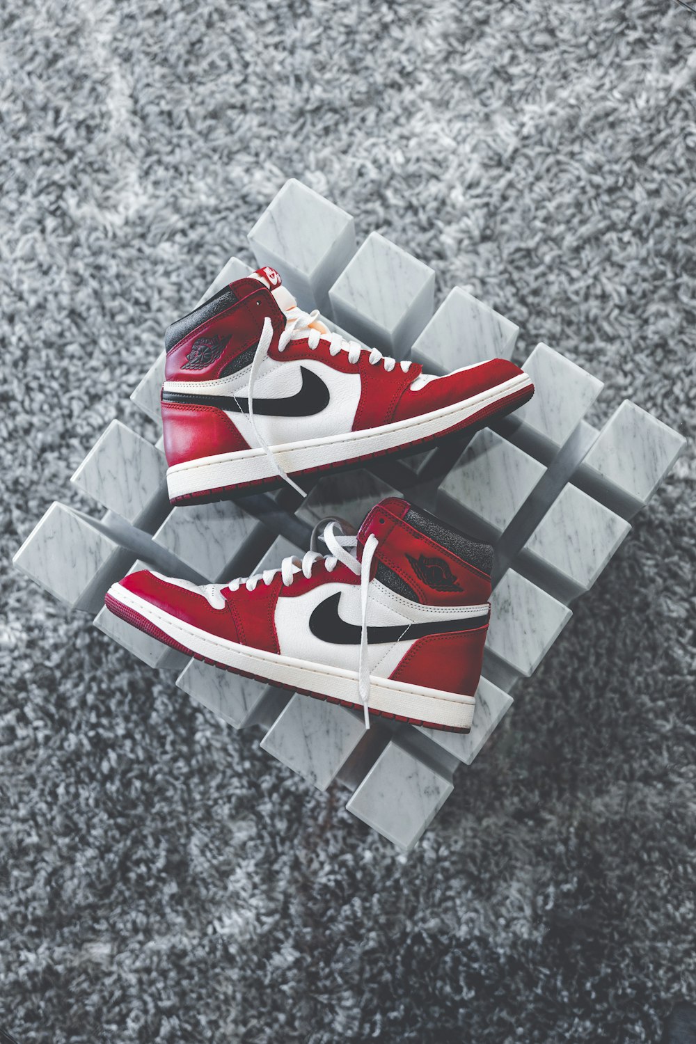 a pair of red sneakers sitting on top of a metal rack