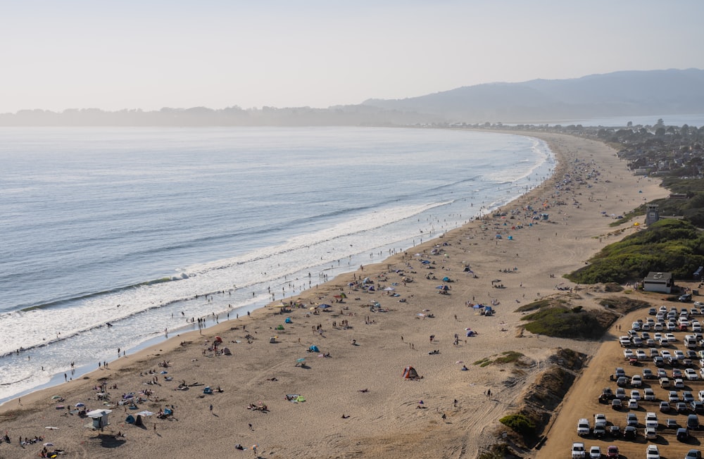 a beach filled with lots of people next to the ocean