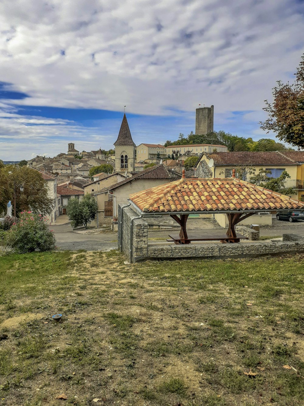 a small building with a tiled roof in the middle of a field