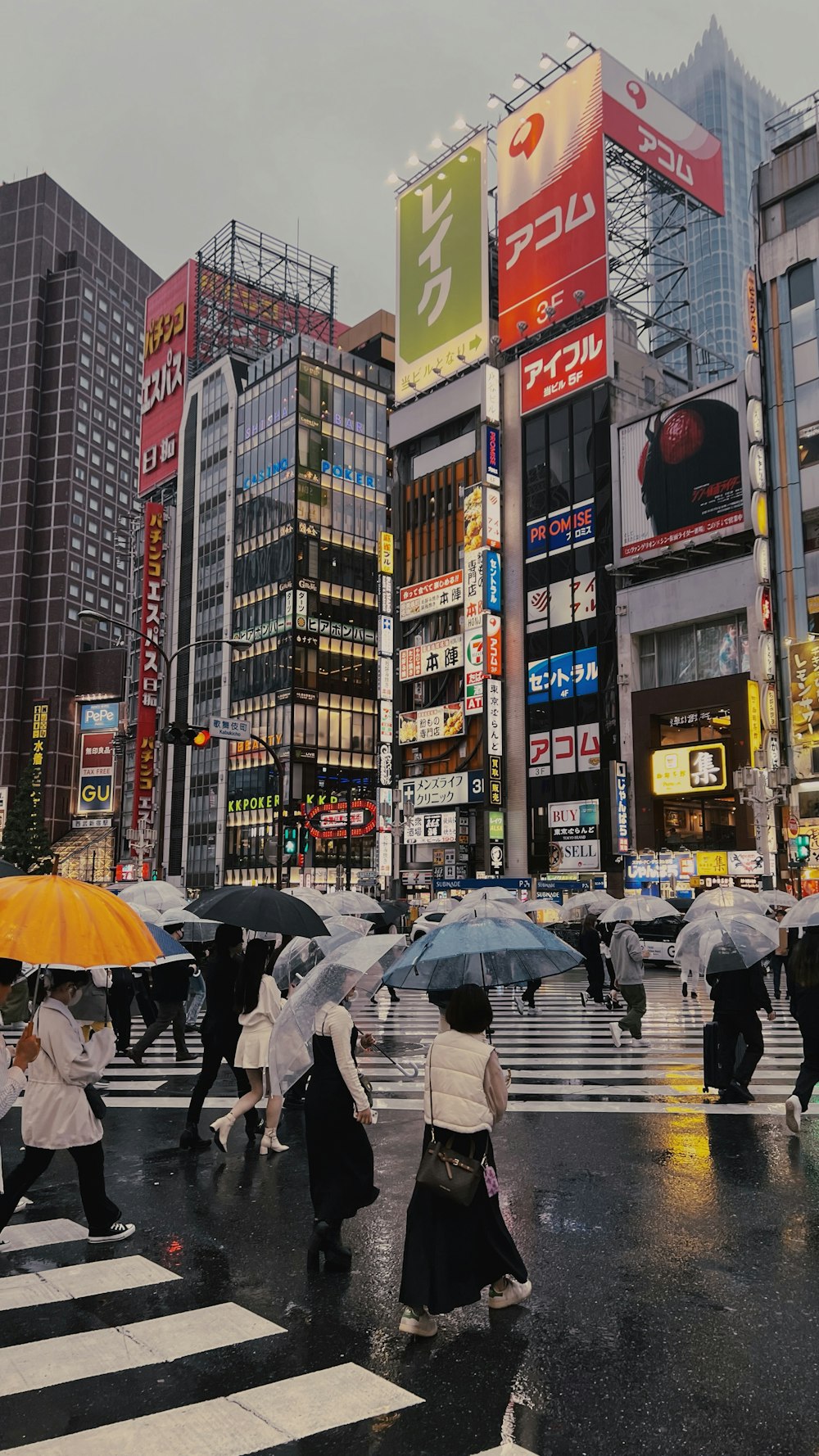 傘を持って通りを横切って歩く人々のグループ